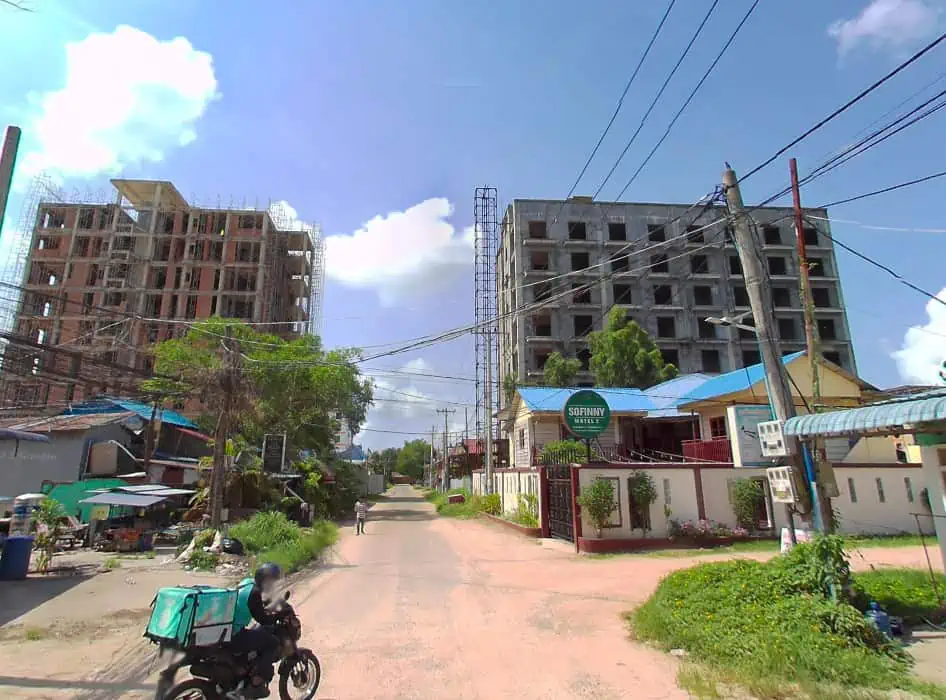 parts of sihanoukville still looking a bit like the past with firt roads and small houses, however the construction behind is a sign of the future