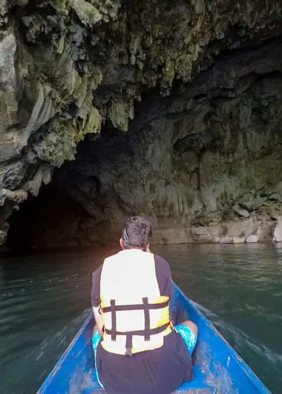 a man on a longtail boat going back through kong lor cave