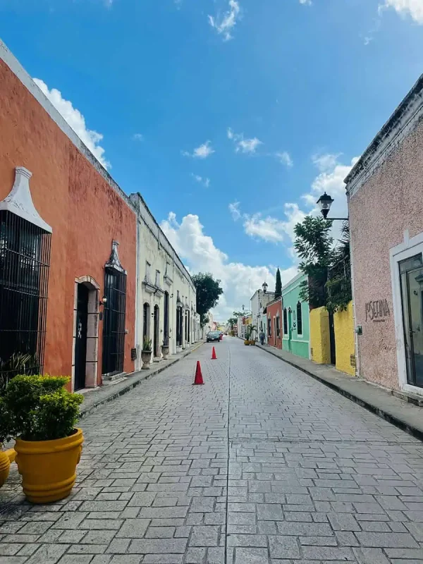 Mexico And Belize Itinerary: From 2 to 5 Weeks 15 Charming street scene in Valladolid, with brightly painted buildings lining a cobblestone road under a clear blue sky. The vibrant facades and quaint atmosphere make it a delightful destination on a Mexico and Belize itinerary