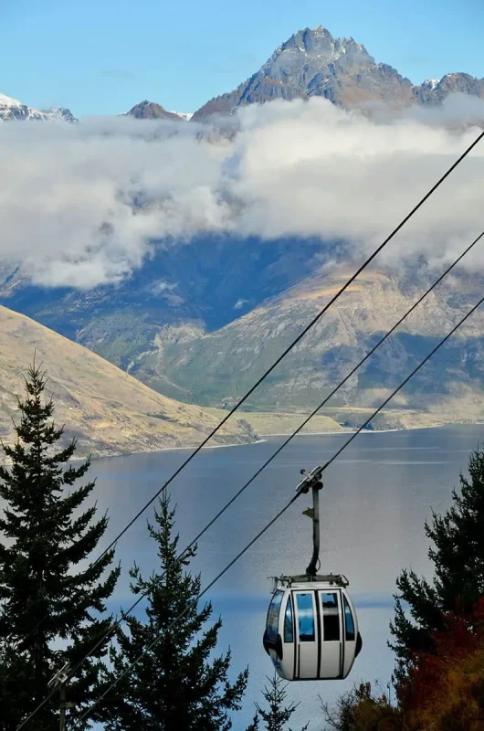 A gondola above Lake Wakatipu with mountain peaks in the distance