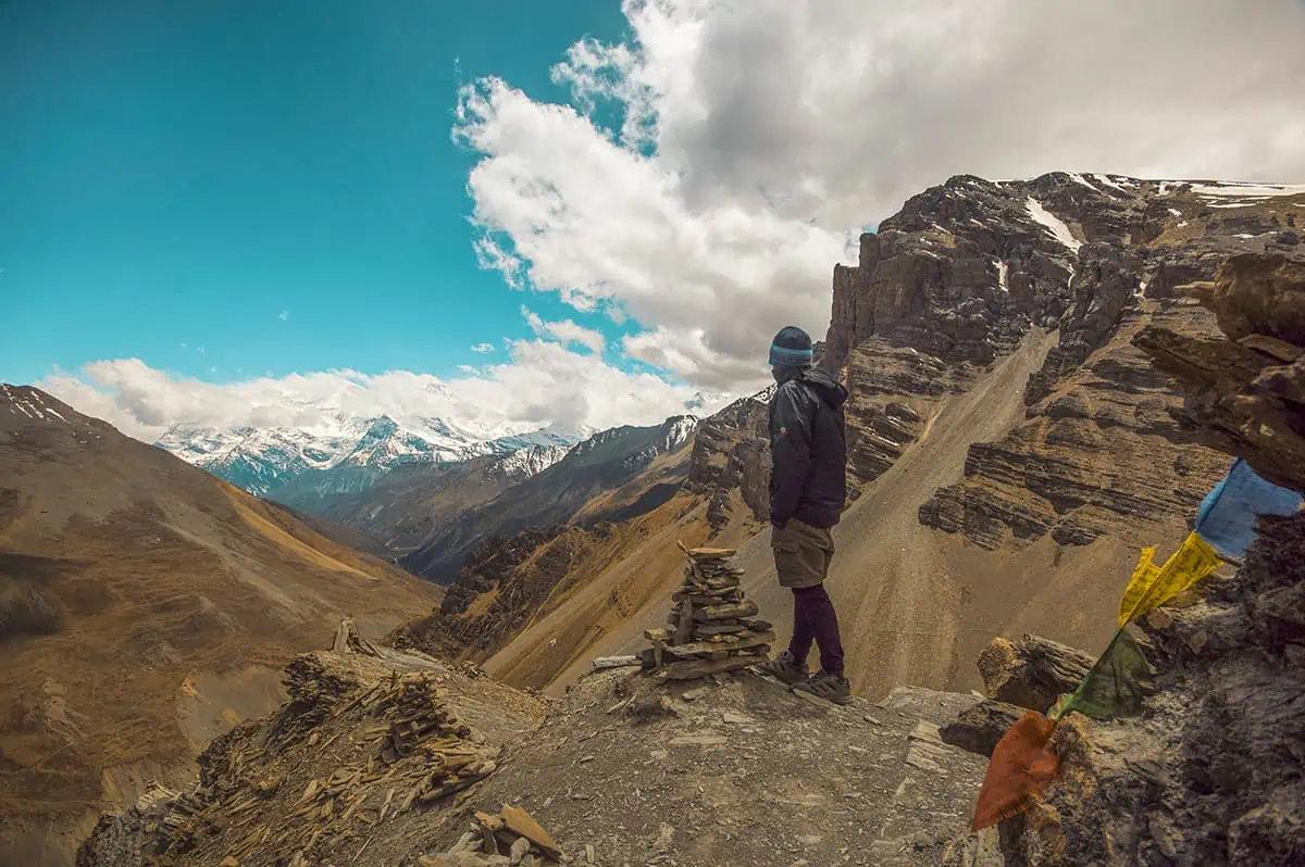 A man standing on top of a rocky mountain on the annapurna circuit