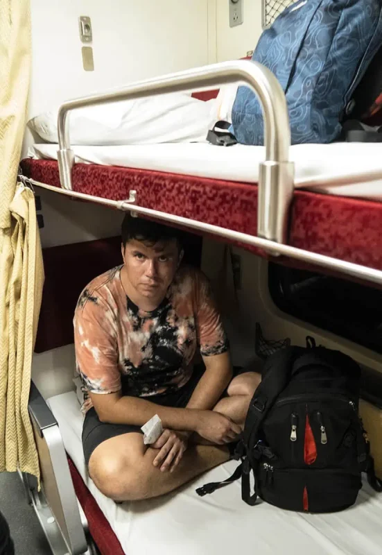 A passenger looking unamused but comfortable in the lower berth of the sleeper train to Chiang Mai.