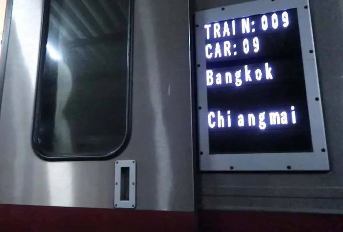 Passengers boarding Train Number 9 for the Bangkok to Chiang Mai overnight sleeper train, showcasing its exterior.