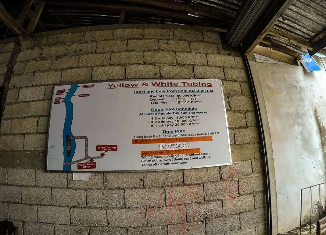 A sign detailing the rental and schedule information for yellow and white tubing activities, with a map of the route and various service notes.
