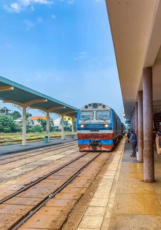 The blue and orange sleeper train ready for an overnight journey, docked at a station with clear skies above