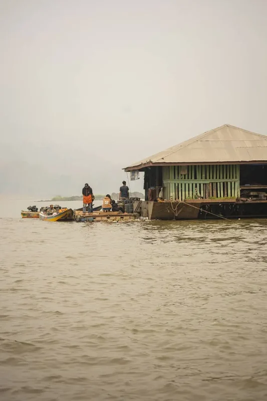 A floating market by the Mekong River with locals on boats engaging in daily trade.