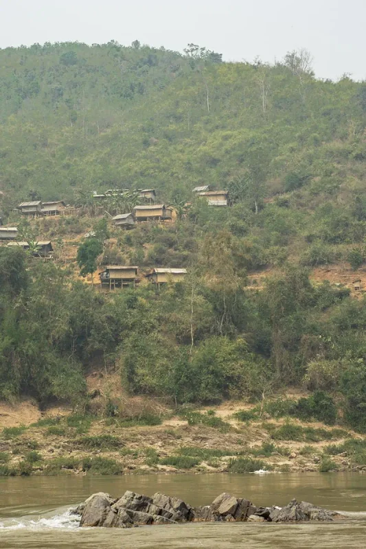 Rustic riverside dwellings dotting the hillside