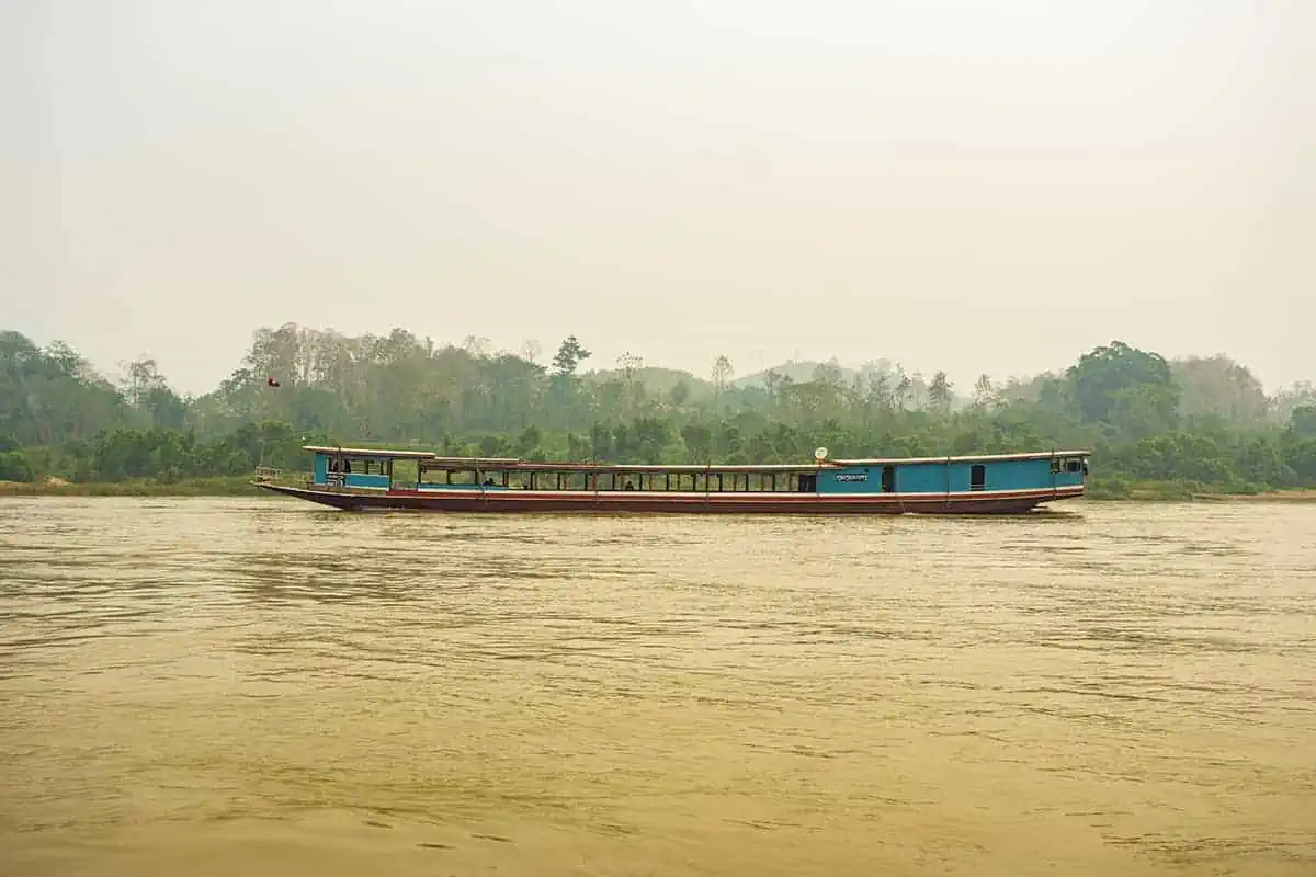 Hazy atmosphere over the Mekong River with a slow boat in the distance