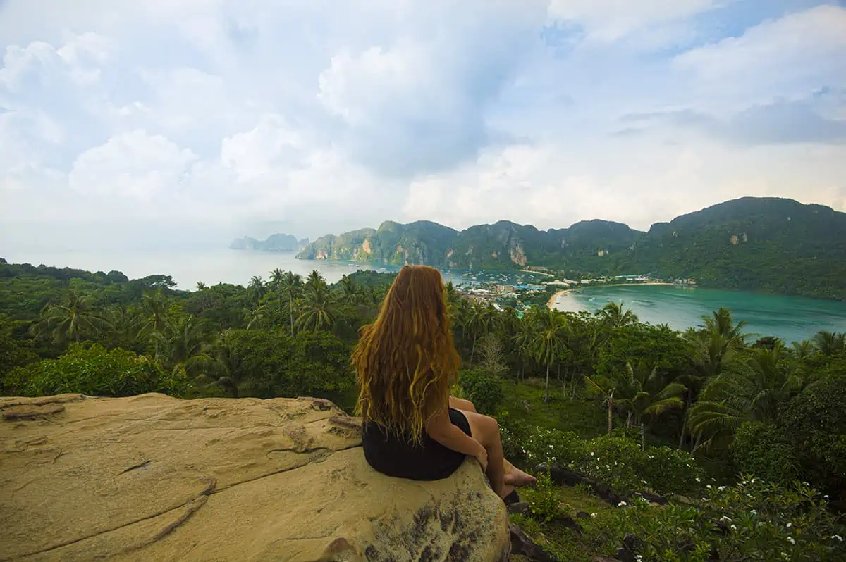 tasha amy enjoys the scenic view atop a rock overlooking the ocean in a backpacker-friendly country of thailand