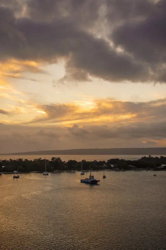 orange sunset with yachts lined up at port vila