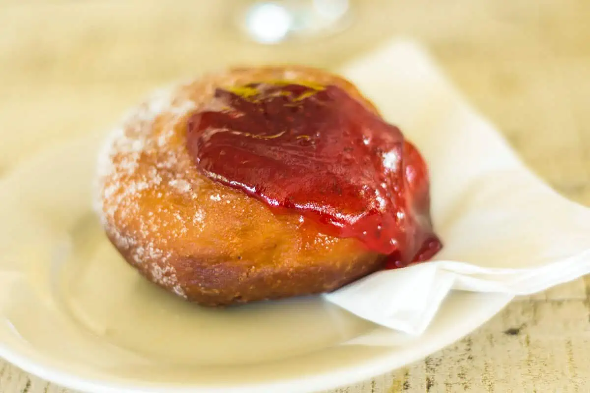 Where To Eat In Rarotonga: BEST Restaurants & Cafes 2025 6 A glistening jam donut dusted with powdered sugar, a sweet treat from LBV that ranks among the best places to eat in Rarotonga.