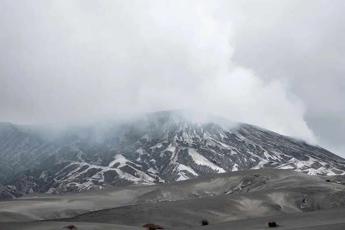 120+ Would You Rather Travel Questions For Ultimate Wanderers 10 A volcanic landscape of Mt Bromo in Java with slopes covered in ash and steam rising from the crater